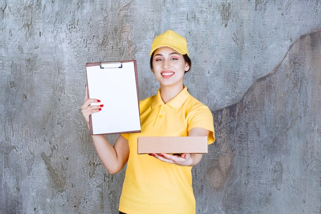 Retrato de mujer mensajero sosteniendo portapapeles con caja de cartón