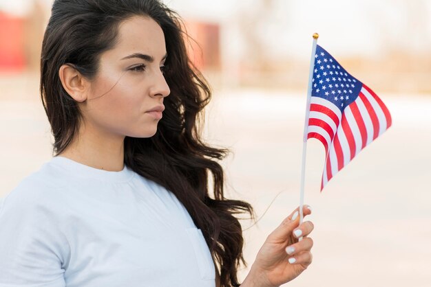 Retrato de mujer mirando la bandera de Estados Unidos