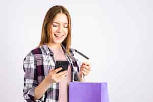 Foto gratuita retrato mujer mirando el teléfono y sosteniendo una bolsa