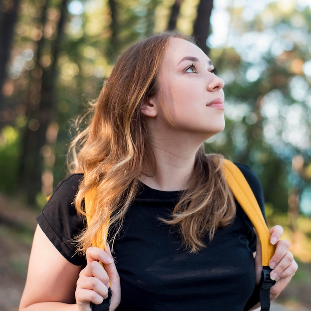 Foto gratuita retrato de mujer con mochila en el bosque