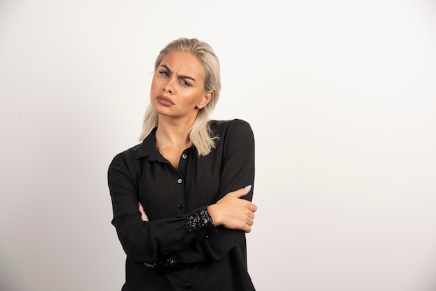 Retrato de mujer de moda en camisa negra posando sobre fondo blanco. Foto de alta calidad