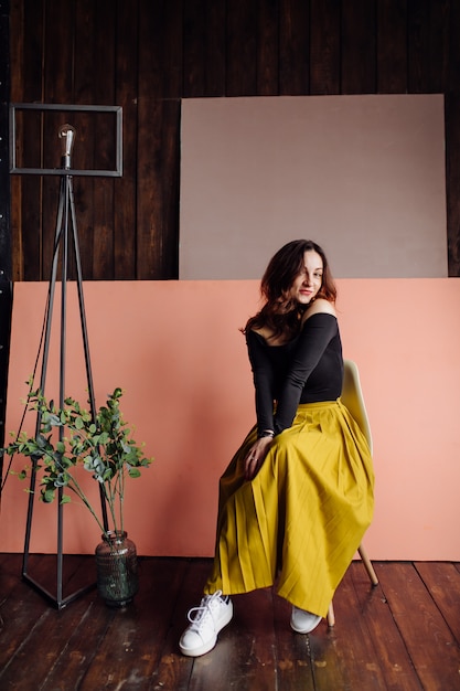 Foto gratuita retrato de una mujer de moda impresionante sentado en una silla