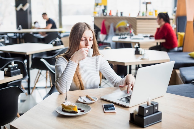 Retrato de mujer moderna trabajando con portátil