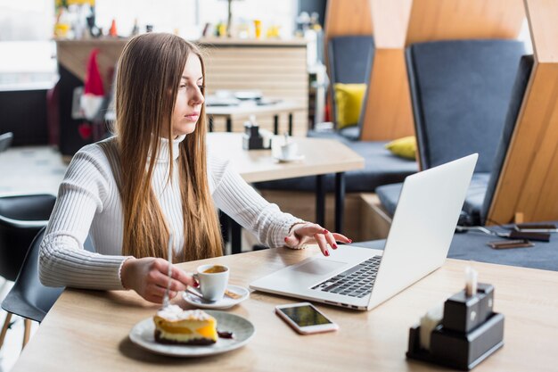 Retrato de mujer moderna trabajando con portátil