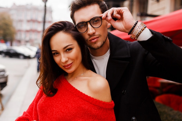 Foto gratuita retrato de mujer morena encantadora feliz y hombre guapo con gafas de cerca. al aire libre. hermosa pareja de enamorados posando sobre el novillo durante sus vacaciones.