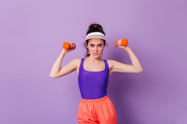 Retrato de mujer morena haciendo ejercicios con mancuernas