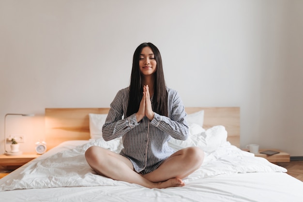 Retrato de mujer morena en pijama corto a rayas