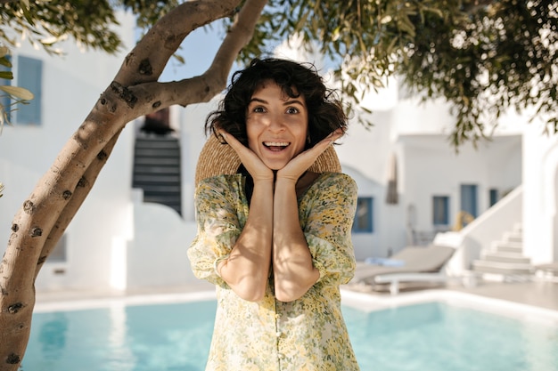 Retrato de mujer morena sorprendida feliz mira al frente