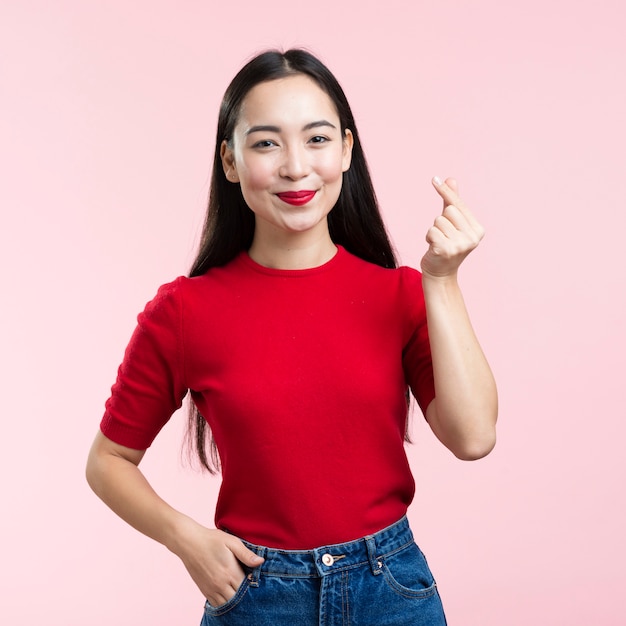 Retrato mujer mostrando signos de corazón con los dedos