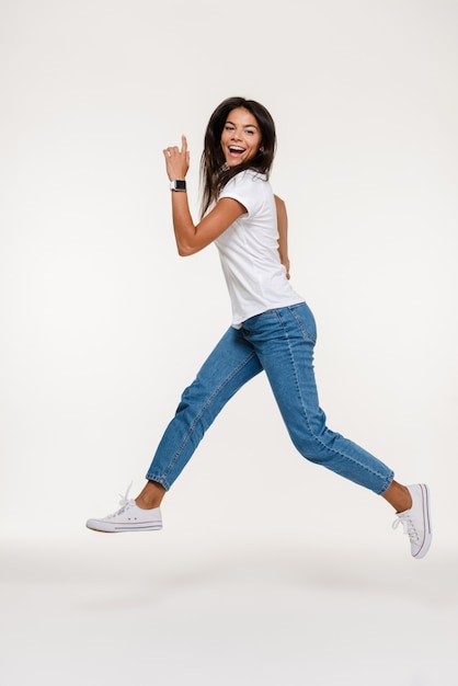 Retrato de una mujer muy feliz saltando