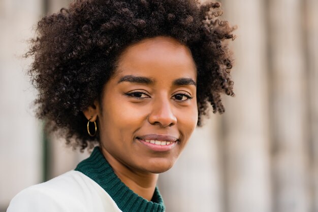 Retrato de mujer de negocios afro de pie al aire libre en la calle