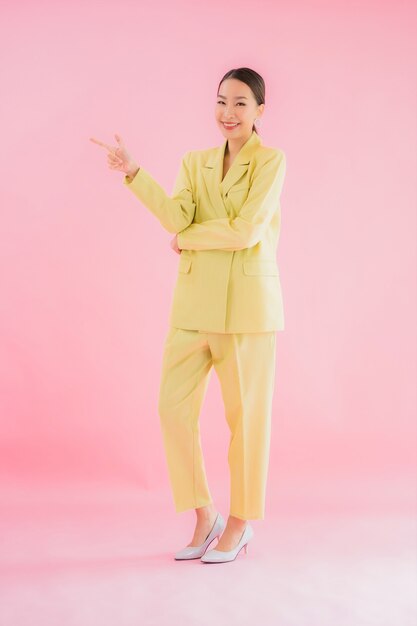 Retrato de mujer de negocios asiática joven hermosa sonrisa en acción en color rosa