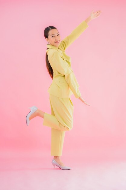 Retrato de mujer de negocios asiática joven hermosa sonrisa en acción en color rosa