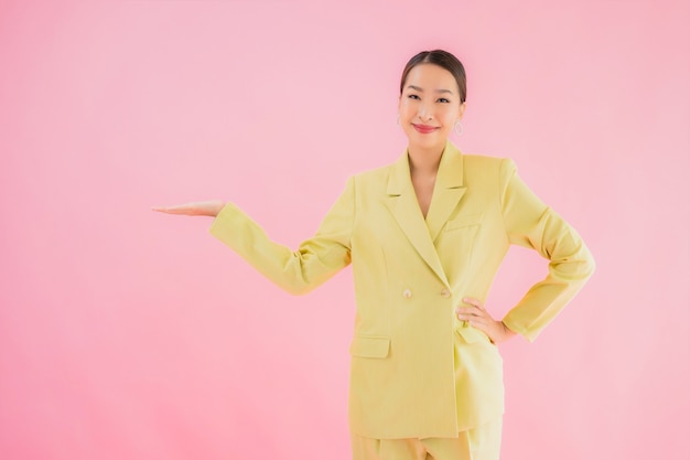 Retrato de mujer de negocios asiática joven hermosa sonrisa en acción en color rosa