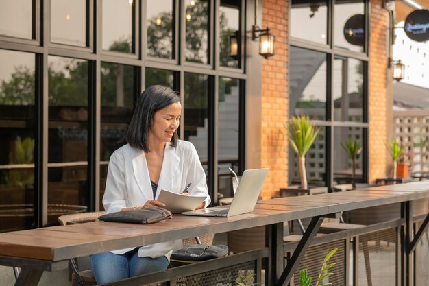 Retrato, de, mujer de negocios, en, un, café, utilizar, un, laptop