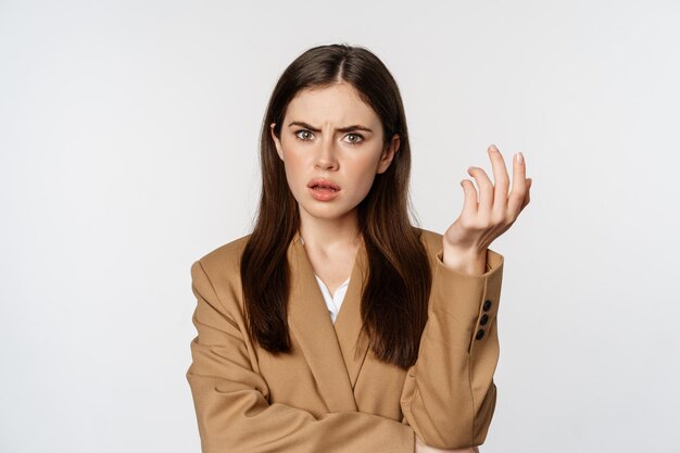 Retrato de mujer de negocios confundida mirando desconcertada y frustrada no puedo entender algo de pie en s...