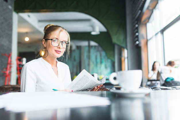 Foto gratuita retrato de una mujer de negocios con periódico