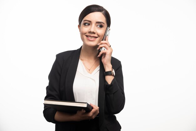 Retrato de mujer de negocios con portátil hablando por teléfono.