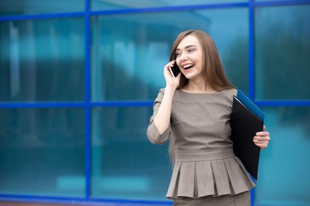 Retrato de mujer de negocios riendo mientras habla por teléfono móvil. Copiar espacio