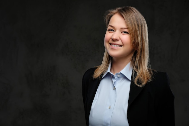 Retrato de una mujer de negocios rubia sonriente vestido formal. Aislado en un fondo de textura oscura.