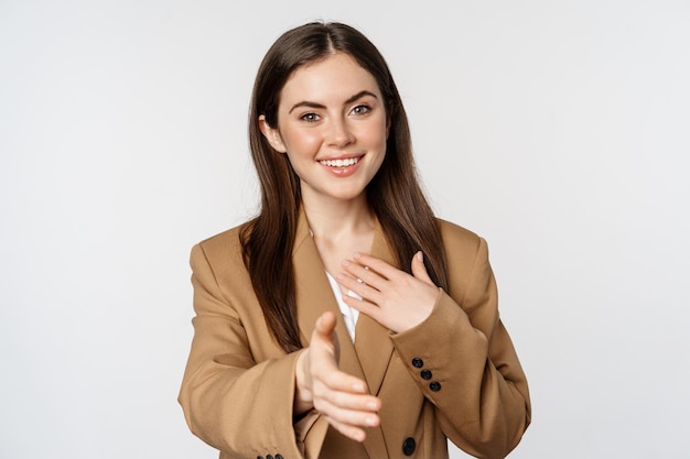 Retrato de una mujer de negocios sonriente extendiendo la mano para un saludo de apretón de manos...