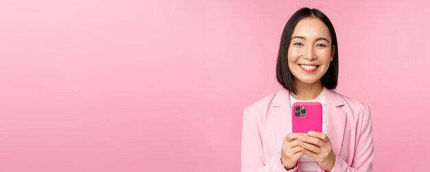 Retrato de una mujer de negocios sonriente persona corporativa asiática que usa una aplicación de teléfono móvil para teléfonos inteligentes