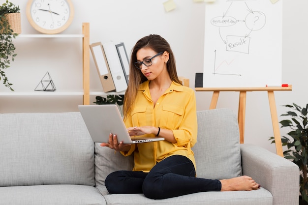 Foto gratuita retrato de mujer de negocios trabajando en sofá