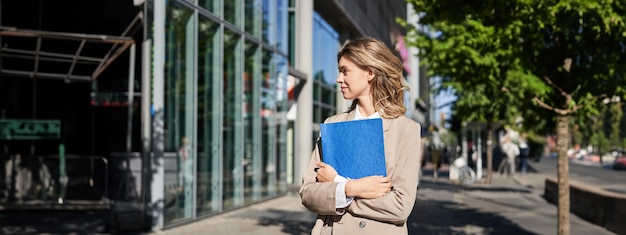 Retrato de una mujer de negocios con traje beige y tacones altos caminando por la calle mujer corporativa yendo a