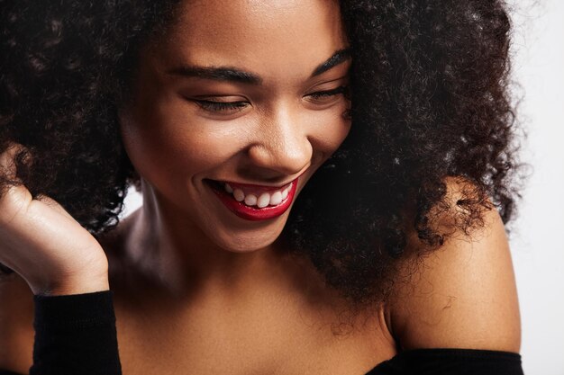 Retrato de mujer negra riendo con labios brillantes y brillantes