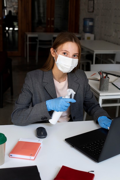 Retrato de mujer en la oficina con mascarilla