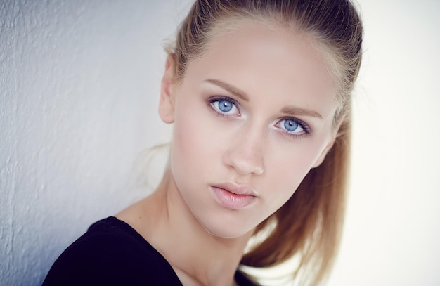 Retrato de mujer de ojos azules con un vestido negro.