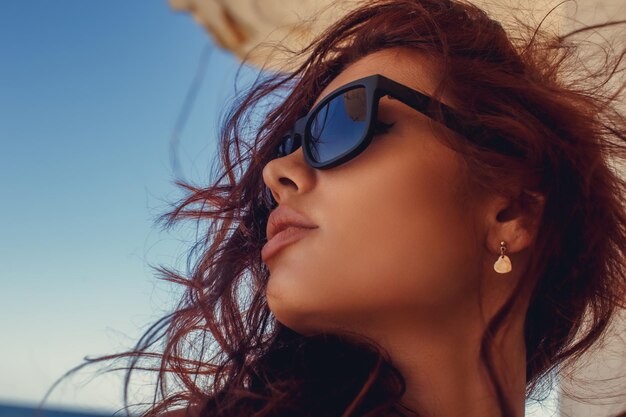 Retrato de una mujer pelirroja con gafas de sol.
