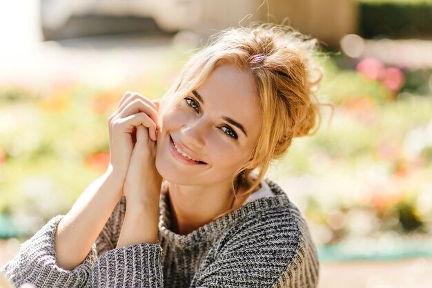 Retrato de mujer pelirroja de ojos verdes posando sentada en casa verde