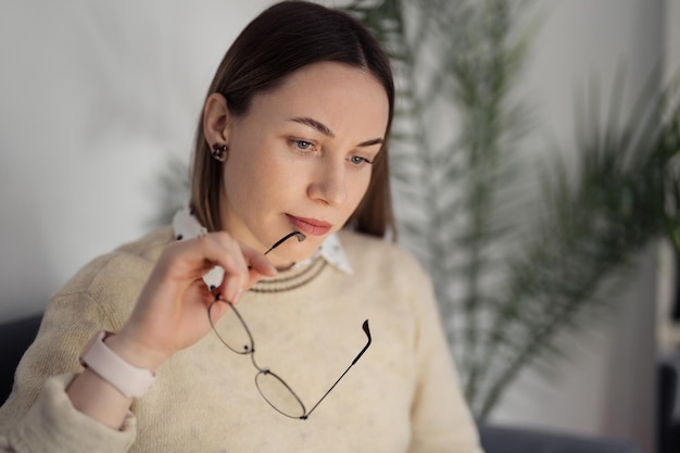 Retrato de una mujer pensativa con gafas Cerebro generando soluciones en algunas situaciones