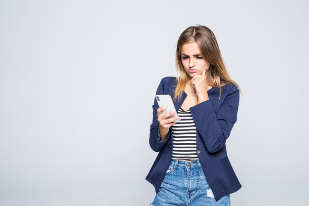 Retrato de una mujer pensativa mediante teléfono móvil aislado