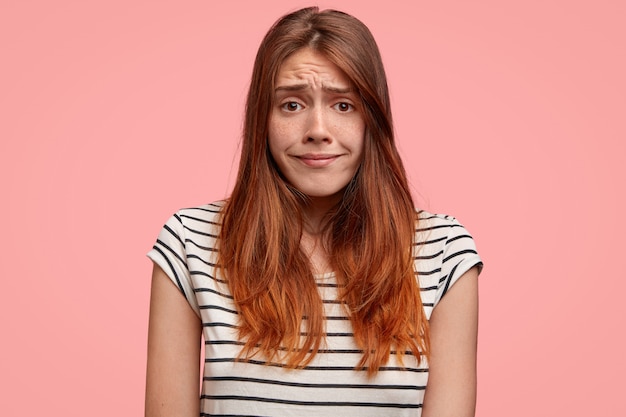 Foto gratuita retrato de mujer perpleja frunce el ceño con insatisfacción, tiene expresión triste, se siente avergonzada. personas, expresiones faciales