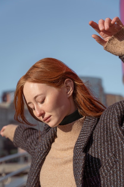 Retrato de mujer posando afuera contra el cielo