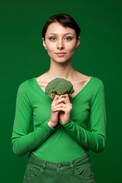 Retrato de mujer posando con brócoli