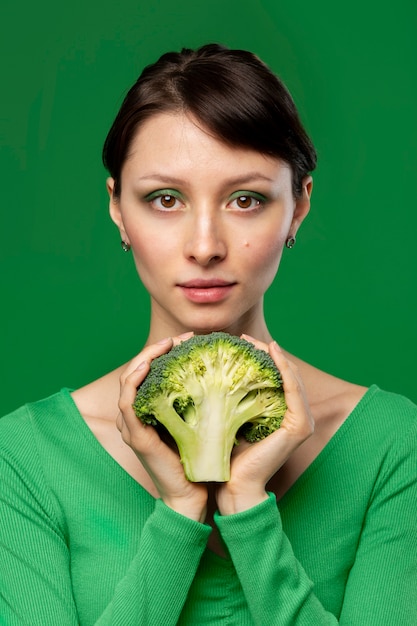 Retrato de mujer posando con brócoli