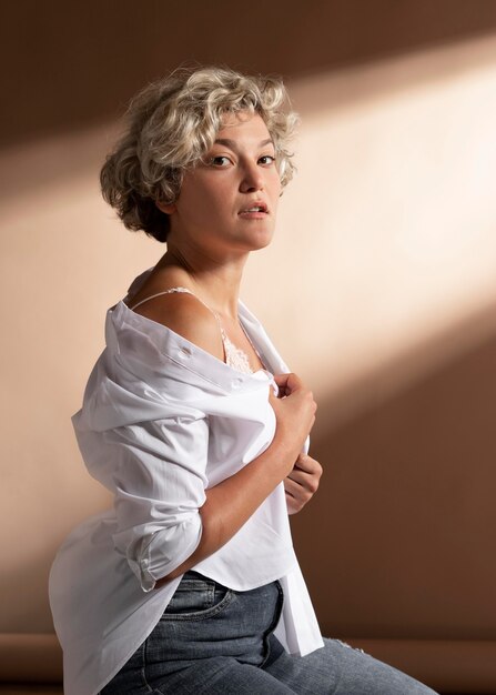 Retrato de mujer posando con camisa blanca y mostrando su sujetador