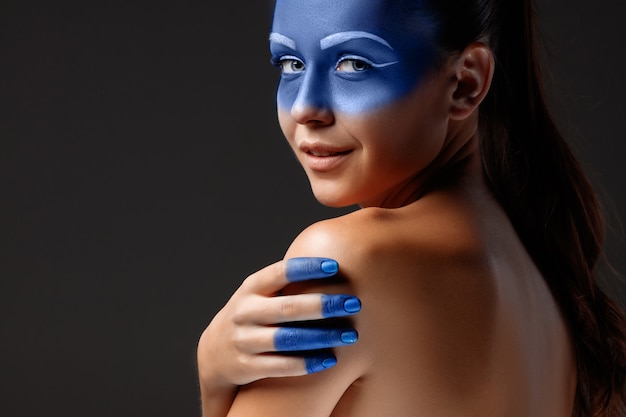 Retrato de una mujer posando cubierta con pintura azul