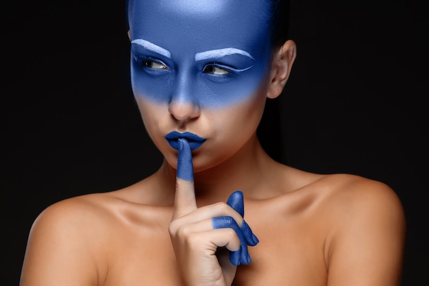 Retrato de una mujer posando cubierta con pintura azul