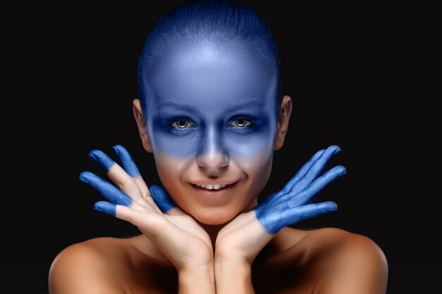 Retrato de una mujer posando cubierta con pintura azul