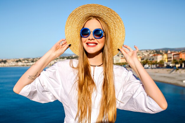 Retrato de mujer posando junto al mar azul