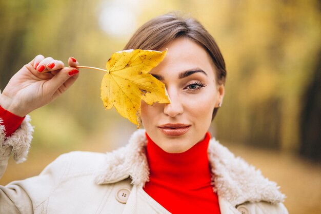 Retrato de mujer que cubre media cara con una hoja