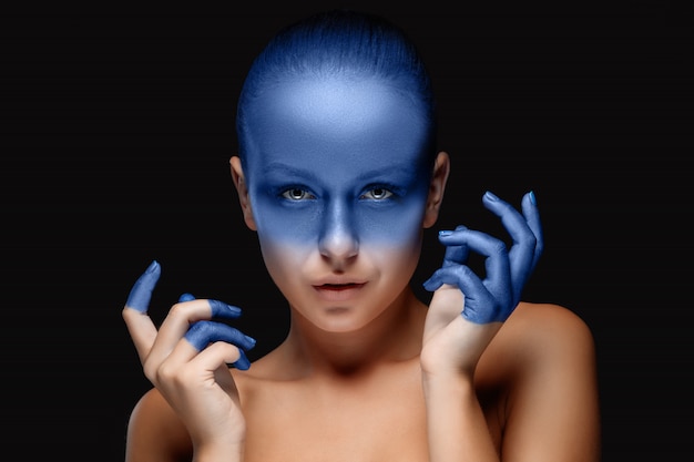 Foto gratuita retrato de una mujer que está posando cubierta con pintura azul