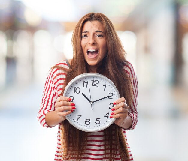 Retrato de la mujer que sostiene el reloj y gritando