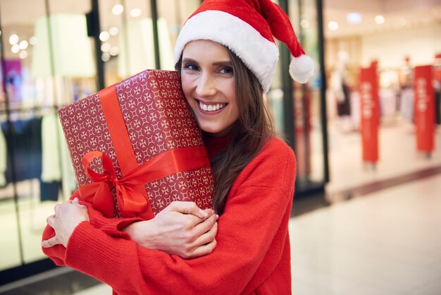 Retrato de mujer con regalo de Navidad en la tienda