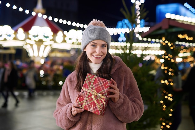 Retrato de mujer con regalos en el mercado de Navidad