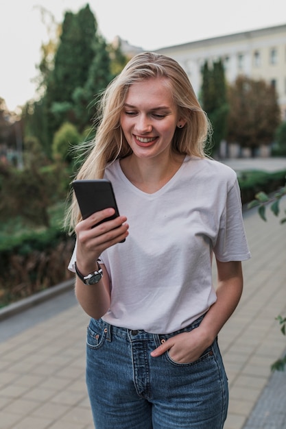 Foto gratuita retrato de una mujer revisando su teléfono